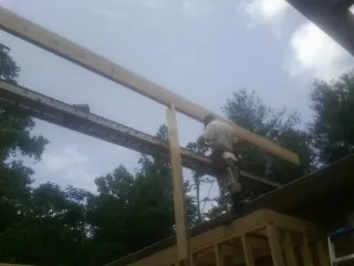 Carpenter setting a ridge beam over a new addition frame — Ice Dam Removal by Roofing Brothers in Horse Shoe