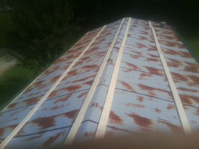 Rusted metal roof panels with new wood purlins before replacement — Storm Damage Roof Repair in Horse Shoe by Roofing Brothers