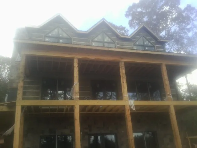 Dormers and porch framing on a large log home under construction — Roof Coating work by our crew in Horse Shoe