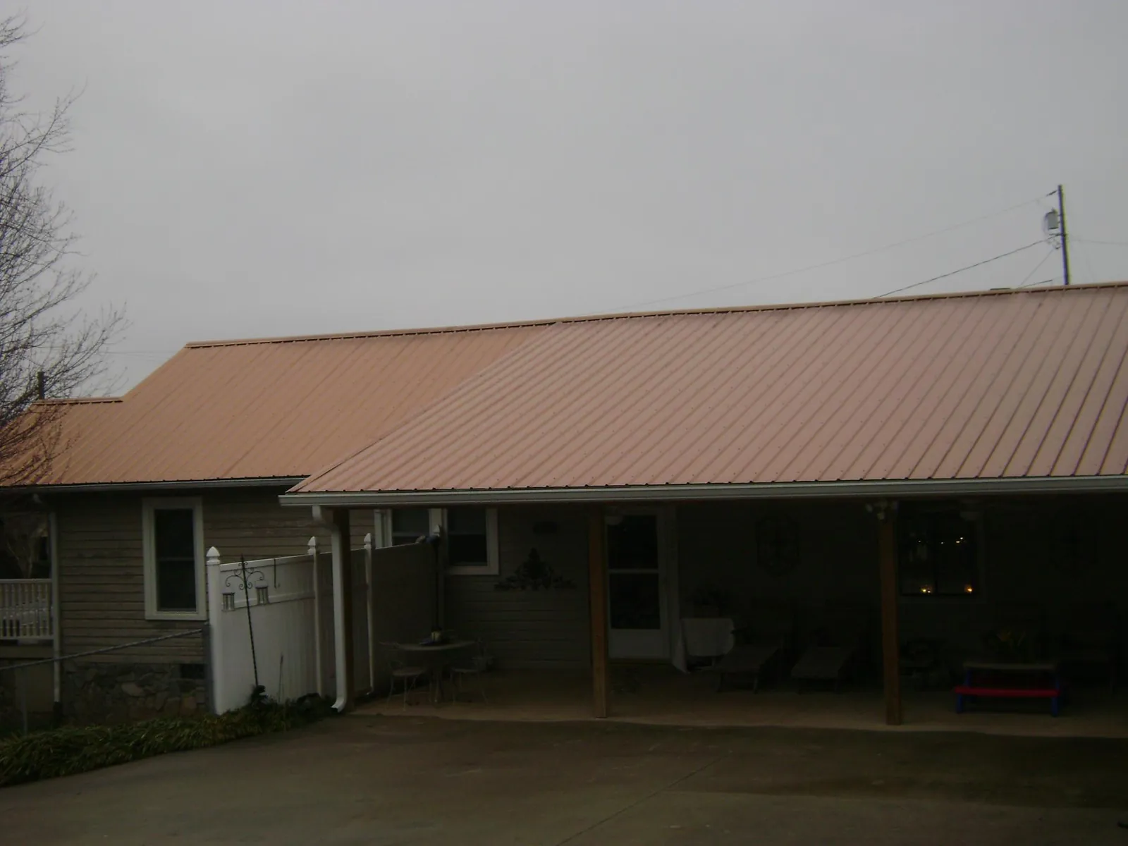 Copper toned metal roof over a wide covered patio in Horse Shoe